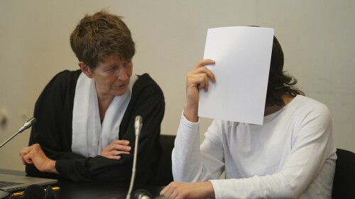 The defendant, right, a suspected IS returnee, sits next to his lawyer Gabriele Heinecke at the beginning of the trial day in the courtroom in the Criminal Justice Building in Hamburg, Germany, Wednesday, July 19, 2023. A German woman convicted on charges that she and her husband allowed the death by thirst of a 5-year-old Yazidi girl she and her husband kept as a slave when they were members of the Islamic State group in Iraq has expressed remorse at the start of a new sentencing hearing. (Marcus Brandt/dpa via AP)
