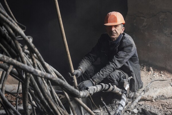 A worker takes a break from clearing the rubble near a transformer which was destroyed after a Russian missile attack at DTEK's power plant in Ukraine, on Monday, April 1, 2024. Russia is attacking Ukraine’s energy sector with renewed intensity and alarming accuracy, signaling to Ukrainian officials that Russia is armed with better intelligence and fresh tactics in its campaign to annihilate the country’s power generation capacity. (AP Photo/Evgeniy Maloletka)
