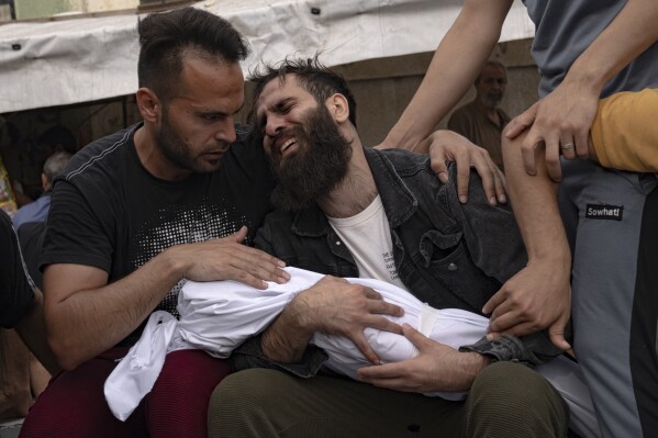 Palestinians mourn their relatives killed in the Israeli bombardment of the Gaza Strip in a morgue in Khan Younis, Sunday, Oct. 29, 2023. ( AP Photo/Fatima Shbair)