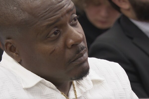 Jermaine Hudson listens as Bobby Gumpright speaks to lawmakers at a packed committee room at the state Capitol on Tuesday, April 29 in Baton Rouge, La. (AP Photo/Stephen Smith)