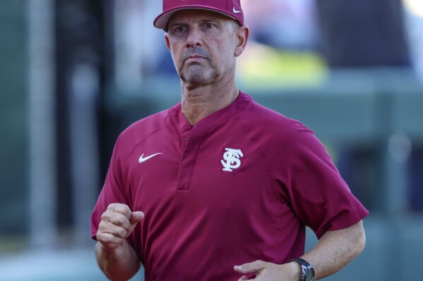 FILE - Florida State head coach Link Jarrett jogs to the dugout before an NCAA baseball game against Florida, March 12, 2024, in Gainesville, Fla. This season has been quite a bounce-back for Jarrett and the Seminoles, at least so far. The Seminoles are 18-0 and the only unbeaten team in Division I after sweeping Notre Dame at home over the weekend. (AP Photo/Gary McCullough, File)