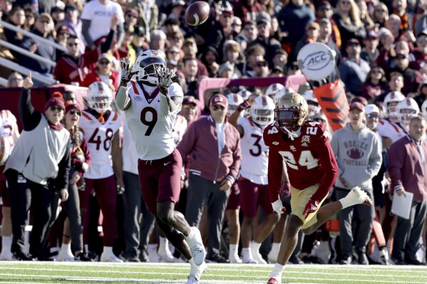 Virginia Tech wide receiver Da'Quan Felton (9) hauls in a pass while being pursued by Boston College cornerback Amari Jackson (24) during the first half of an NCAA college football game Saturday, Nov. 11, 2023 in Boston. (AP Photo/Mark Stockwell)