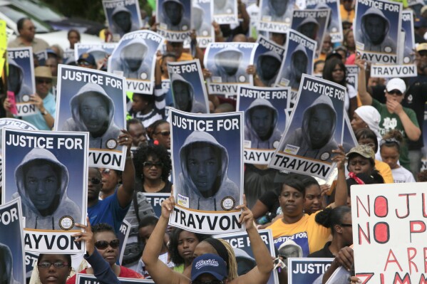 FILE - Protesters hold signs during a march and rally for slain teenager Trayvon Martin, March 31, 2012, in Sanford, Fla. The Black Lives Matter movement hits a milestone on Thursday, July 13, 2023, marking 10 years since its 2013 founding in response to the acquittal of the man who fatally shot Martin. Gunned down in a Florida gated community where his father lived in 2012, Martin was one of the earliest symbols of a movement that now wields influence in politics, law enforcement and broader conversations about racial progress. (AP Photo/Julie Fletcher, File)