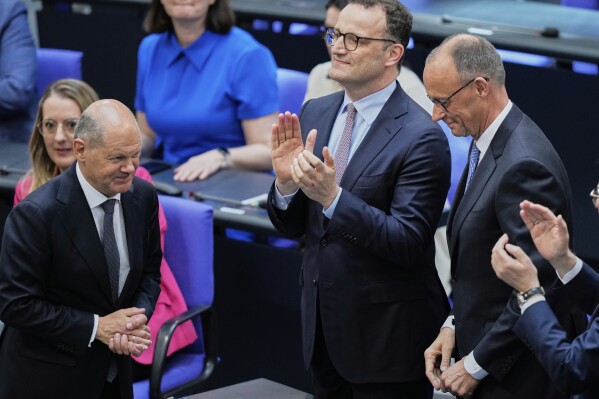 Leader of the Christian Democrats Friedrich Merz is congratulated by outgoing Chancellor Olaf Scholz after being elected new chancellor at the German federal parliament, Bundestag, at the Reichstag building in Berlin, Germany, Tuesday, May 6, 2025. (AP Photo/Ebrahim Noroozi)
