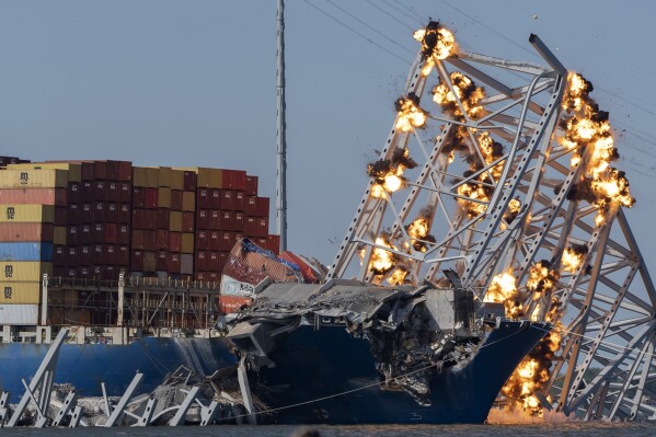 FILE - Explosive charges are detonated to bring down sections of the collapsed Francis Scott Key Bridge resting on the container ship Dali on Monday, May 13, 2024, in Baltimore. (AP Photo/Mark Schiefelbein, file)