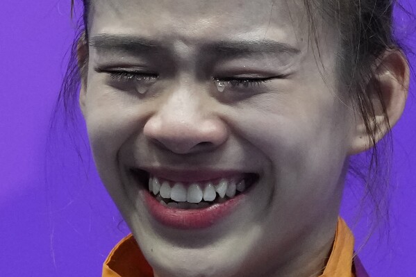 Silver medalist Malaysia's Tan Cheong Min cries on the podium during the award ceremony for the Wushu Women's Nanquan & Nandao All-Round competition for the 19th Asian Games in Hangzhou, China, Tuesday, Sept. 26, 2023. (AP Photo/Ng Han Guan)