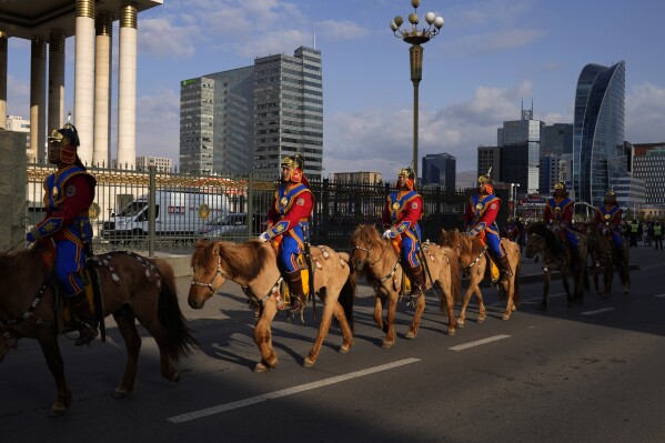 Horse-mounted Mongolian army soldiers ride in their ceremonial uniforms in Ulaanbaatar, the capital of Mongolia, Sunday, May 21, 2023. (AP Photo/Manish Swarup)