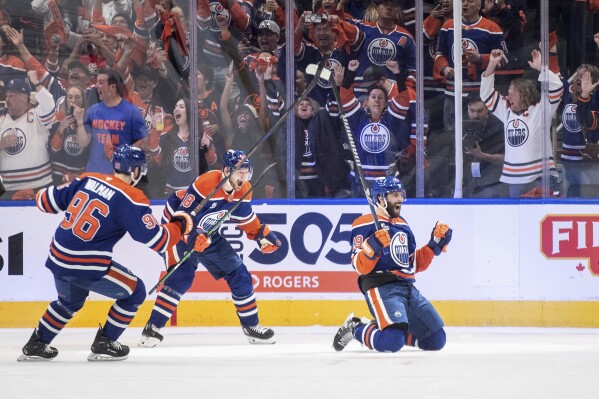 Edmonton Oilers' Adam Henrique (19), Jake Walman (96) and Zach Hyman (18) celebrate after a goal against the Vegas Golden Knights during the first period of Game 4 of a second-round NHL hockey playoff series in Edmonton, Alberta, Monday, May 12, 2025. (Jason Franson/The Canadian Press via AP)