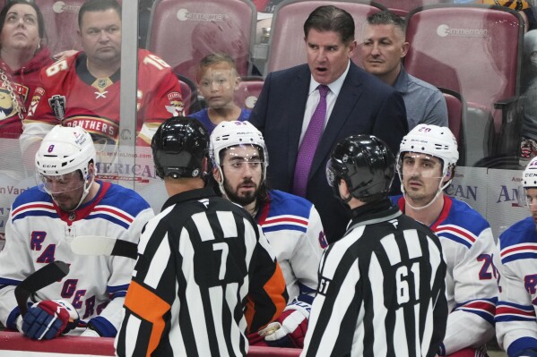 New York Rangers head coach Peter Laviolette, center, rear, talks with officials during the third period of an NHL hockey game against the Florida Panthers, Monday, April 14, 2025, in Sunrise, Fla. (AP Photo/Lynne Sladky)