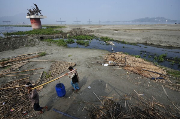 Two men carry water from Brahmaputra River on World Water Day in Guwahati, India, March 22, 2024. (AP Photo/Anupam Nath)