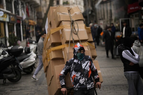 A man pulls a trolley with goods in Eminonu commercial area in Istanbul, Turkey, Thursday, Jan. 25, 2024. Turkey's central bank raised its key interest rate by another 2.5 percentage points on Thursday, pressing ahead with a series of borrowing cost increases aimed at combatting inflation that reached nearly 65% in December. (AP Photo/Francisco Seco)