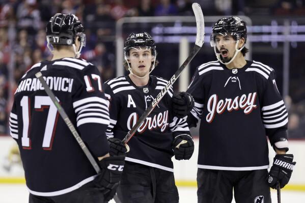 New Jersey Devils center Jack Hughes (86) is congratulated by teammates after scoring his second goal of the third period against the New York Rangers during an NHL hockey game on Tuesday, March 22, 2022, in Newark, N.J. The Devils won 7-4. (AP Photo/Adam Hunger)
