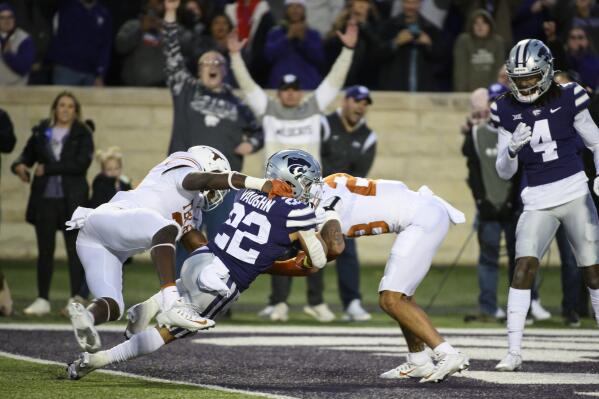 Kansas State running back Deuce Vaughn (22) scores a touchdown while being tackled by Texas defensive back Kitan Crawford, left, and Texas defensive back Jerrin Thompson, right, during the first half of an NCAA college football game Saturday, Nov. 5, 2022, in Manhattan, Kan. (AP Photo/Reed Hoffmann)