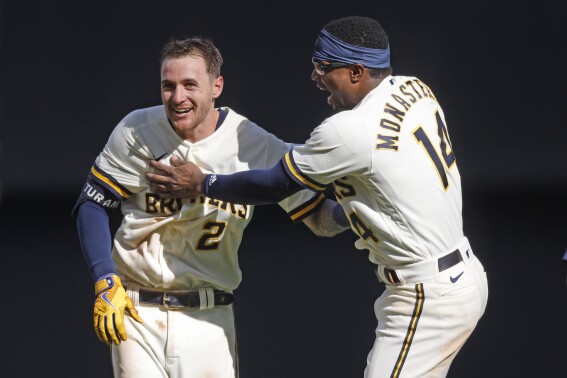 Milwaukee Brewers' Brice Turang is congratulated by Andruw Monasterio (14) after Turang drove in the winning run against the Minnesota Twins during the 10th inning of a baseball game Wednesday, Aug. 23, 2023, in Milwaukee. (AP Photo/Jeffrey Phelps)