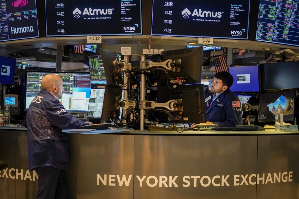 FILE -Traders work at their stations at the New York Stock Exchange, Friday, May 26, 2023, in New York. Corporate profits should have hit bottom already: After falling for much of the last year, S&P 500 companies are expected to report 0.2% profit growth for the summer. While that sounds anemic, it would be the first quarter of growth in a year, according to FactSet. For three straight quarters, profits have fallen from year-ago levels due to pressure from higher costs and a fragile global economy. Hopes for a return to growth are crucial for the stock market to extend this year’s rally. (AP Photo/John Minchillo, File)