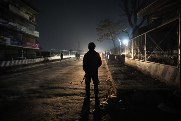 An Indian paramilitary soldier stands guard near the site of a shootout in Srinagar, Indian controlled Kashmir, Wednesday, Feb. 7, 2024. Assailants fatally shot a non-local worker and wounded another in the main city of Indian-controlled Kashmir late Wednesday, police said and blamed militants fighting against Indian rule in the disputed region for the attack. (AP Photo/Mukhtar Khan)