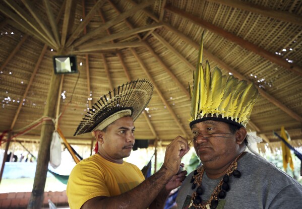 Members of the Mura Indigenous community perform traditional painting at a gathering in the Moyray village, in Autazes, Amazonas state, Brazil, Friday, Feb. 21, 2025. (AP Photo/Edmar Barros)