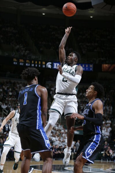 Michigan State's Rocket Watts, center, puts up a shot against Duke's Vernon Carey Jr., left, and Tre Jones, right, during the second half of an NCAA college basketball game, Tuesday, Dec. 3, 2019, in East Lansing, Mich. (AP Photo/Al Goldis)