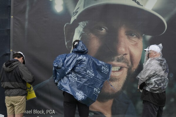 Fans leaves the course past a banner of club pro Michael Block after weather delay during a practice round for the PGA Championship golf tournament at the Valhalla Golf Club, Tuesday, May 14, 2024, in Louisville, Ky. (Ǻ Photo/Jeff Roberson)