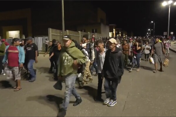 In this image from a video, a migrants caravan leaves San Pedro Sula, Honduras early Saturday, Jan. 20, 2024. A caravan of some 500 migrants that departed northern Honduras in hopes of reaching the United States dissolved Sunday after crossing the border into Guatemala, the Guatemalan Migration Institute reported. (AP Photo)