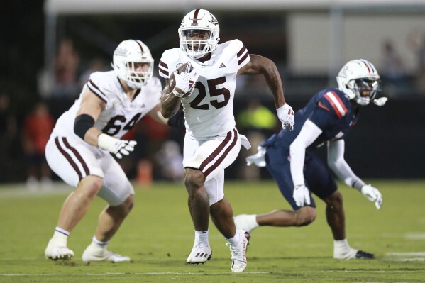 Mississippi State running back Jeffery Pittman (25) sprints past offensive lineman Steven Losoya III (64) for an overtime touchdown against Arizona during an NCAA college football game, Saturday, Sept. 9, 2023, in Starkville, Miss. (Thomas Wells/The Northeast Mississippi Daily Journal via AP)