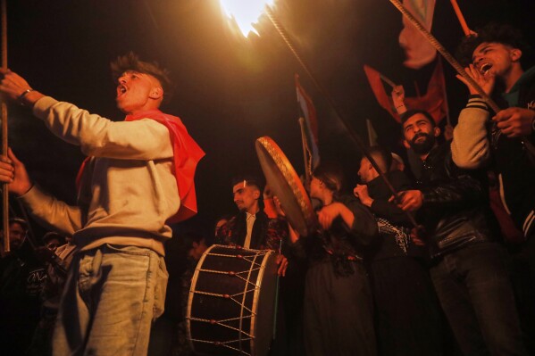 Syrian Kurds holding lit torches celebrate their Nowruz, the Kurdish New Year in Amuda, Hasaka region, northeastern Syria, Thursday, March 20, 2025. (AP Photo/Baderkhan Ahmad)