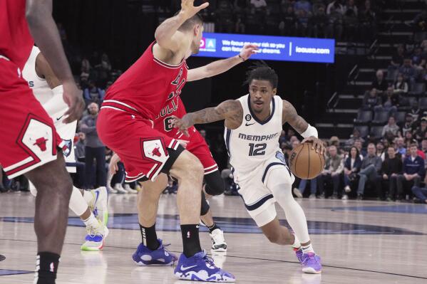 Memphis Grizzlies' Ja Morant (12) drives past Chicago Bulls' Nikola Vucevic (9) during the first half of an NBA basketball game Tuesday, Feb. 7, 2023, in Memphis, Tenn. (AP Photo/Karen Pulfer Focht)