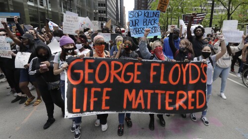 FILE - Protesters hold signs as they march during a protest over the death of George Floyd in Chicago, May 30, 2020. Minneapolis must enact police reforms in the wake of George Floyd's murder under a settlement agreement with the state Human Rights Department approved by a local judge Thursday, July 13, 2023. (AP Photo/Nam Y. Huh, File)
