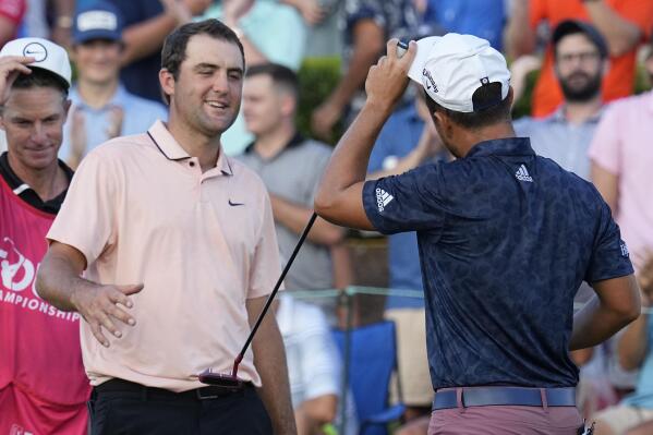 Scottie Scheffler, left, speaks with Xander Schauffele after thier round on the 18th green during the second round of the Tour Championship golf tournament at East Lake Golf Club, Friday, Aug. 26, 2022, in Atlanta. (AP Photo/Steve Helber)
