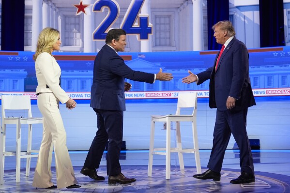 Republican presidential candidate former President Donald Trump greets moderators Martha MacCallum and Bret Baier as he arrives on stage for a Fox News Channel town hall in Des Moines, Iowa, Wednesday, Jan. 10, 2024. (AP Photo/Carolyn Kaster)