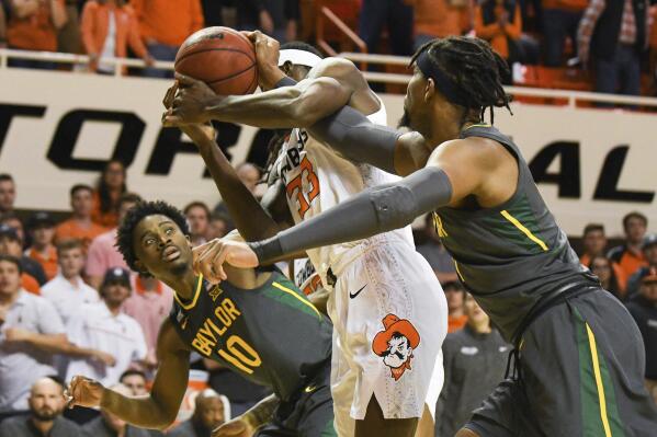 Baylor guard Adam Flagler (10) watches as Oklahoma State forward Moussa Cisse (33) and Baylor forward Flo Thamba (0) struggle for the ball during an NCAA college basketball game Monday, Feb. 21, 2022, in Stillwater, Okla. (AP Photo/Brody Schmidt)
