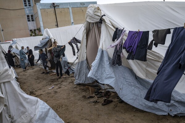 FILE - Palestinians displaced by the Israeli bombardment of the Gaza Strip are seen between tents at a U.N. displacement camp in Khan Younis, Sunday, Nov. 19, 2023. Since the the fighting began, around 22,000 people have taken shelter there. (AP Photo/Fatima Shbair, File)