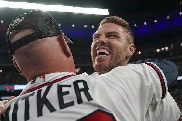 Atlanta Braves manager Brian Snitker hugs Freddie Freeman after winning Game 6 of baseball's National League Championship Series against the Los Angeles Dodgers Sunday, Oct. 24, 2021, in Atlanta. The Braves defeated the Dodgers 4-2 to win the series. (AP Photo/Brynn Anderson)