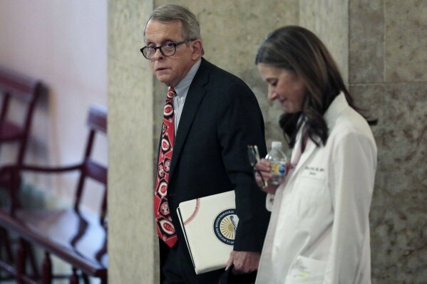Ohio Gov. Mike DeWine, left, and Dr. Amy Acton, director of the Ohio Department of Health, leave the State Room before their daily update on the states response to the ongoing COVID-19 pandemic on Thursday, March 26, 2020 at the Ohio Statehouse in Columbus, Ohio. (Joshua A. Bickel/The Columbus Dispatch via AP)