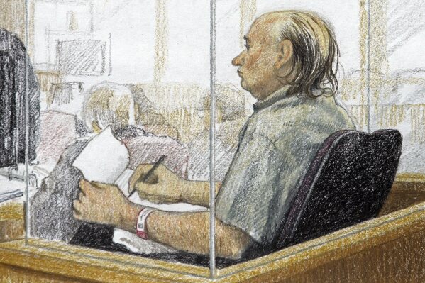 This artist's sketch shows accused serial killer Robert Pickton taking notes during the second day of his trial in B.C. Supreme Court in New Westminster, British Columbia, Jan. 31, 2006. Convicted Canadian serial killer Pickton has been hospitalized and is in a life-threatening condition after an assault at a Quebec prison, authorities said Tuesday, May 21, 2024. (Jane Wolsack/The Canadian Press via AP)