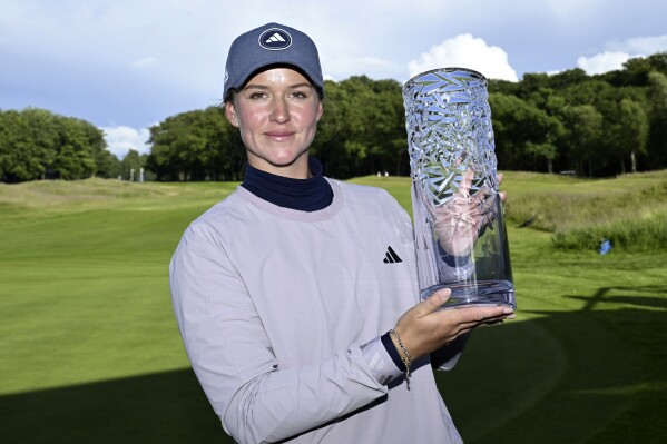 Sweden's Linn Grant raises the trophy after winning the Scandinavian Mixed DP World Tour Championship golf tournament, at Vasatorps Golf Club outside Helsingborg, Sweden, Sunday, June 9, 2024. (Jonas Ekstromer/TT via AP)