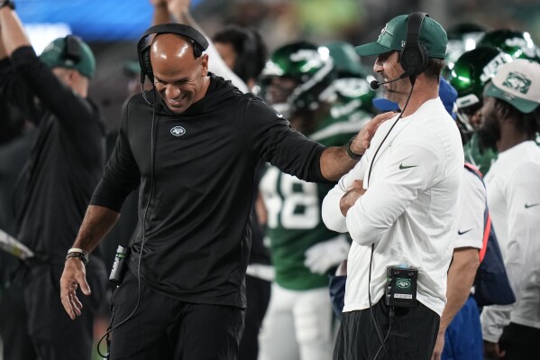 New York Jets' New York Jets' head coach Robert Saleh smiles as he talks to quarterback Aaron Rodgers, right, during the first half of a preseason NFL football game against the Tampa Bay Buccaneers, Saturday, Aug. 19, 2023, in East Rutherford, N.J. (AP Photo/Seth Wenig)