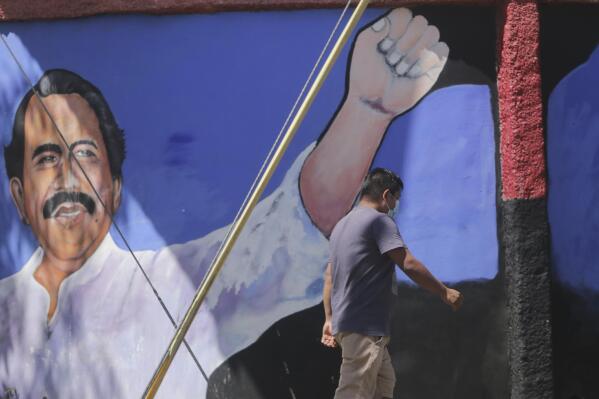 A man walks past a mural of Nicaraguan President Daniel Ortega during general elections in Managua, Nicaragua, Sunday, Nov. 7, 2021. Ortega seeks a fourth consecutive term against a field of little-known candidates while those who could have given him a real challenge sit in jail. (AP Photo/Andres Nunes)