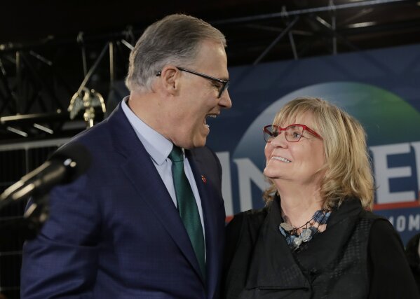 
              Washington Gov. Jay Inslee, left, greets his wife, Trudi Inslee, right, Friday, March 1, 2019, following a campaign event at A&R Solar in Seattle. Inslee announced that he will seek the 2020 Democratic presidential nomination, mixing calls for combating climate change and highlights of his liberal record with an aggressive critique of President Donald Trump. (AP Photo/Ted S. Warren)
            