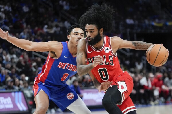 Chicago Bulls guard Coby White (0) drives on Detroit Pistons guard Jared Rhoden (8) in the first half of an NBA basketball game in Detroit, Thursday, April 11, 2024. (AP Photo/Paul Sancya)