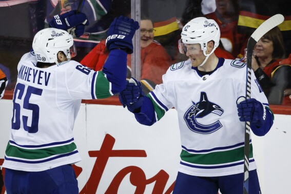 Vancouver Canucks forward Sam Lafferty, right, celebrates his goal with teammate forward Ilya Mikheyev during the first period of an NHL hockey game against the Calgary Flames, Saturday, Dec. 2, 2023 in Calgary, Alberta. (Jeff McIntosh/The Canadian Press via AP)