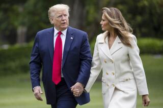 FILE - In this May 25, 2020 photo, President Donald Trump, accompanied by first lady Melania Trump, walks as they return on Marine One on the South Lawn of the White House in Washington, after returning from Fort McHenry National Monument and Historic Shrine, in Baltimore, for a Memorial Day ceremony. (AP Photo/Alex Brandon)