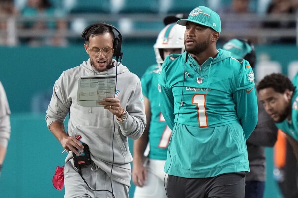 Miami Dolphins head coach Mike McDaniel and Miami Dolphins quarterback Tua Tagovailoa (1) are shown on the sideline in the second half of a preseason NFL football game against the Atlanta Falcons, Friday, Aug. 11, 2023, in Miami Gardens, Fla. (AP Photo/Wilfredo Lee)