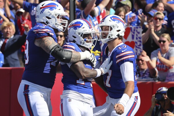 Buffalo Bills wide receiver Stefon Diggs, center, celebrates his touchdown with offensive tackle Spencer Brown, left, and quarterback Josh Allen, right, during the first half an NFL football game against the Miami Dolphins, Sunday, Oct. 1, 2023, in Orchard Park, N.Y. (AP Photo/Jeffrey T. Barnes)