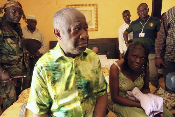 FILE - In this April 11, 2011 file photo, former Ivorian President Laurent Gbagbo, center, and his wife Simone, are seen in the custody of republican forces loyal to election winner Alassane Ouattara, at the Golf Hotel in Abidjan, Ivory Coast. Gbagbo is scheduled to return home to Ivory Coast Thursday June 17, 2021 for the first time in nearly a decade. The move comes after his acquittal on war crimes charges was upheld at the International Criminal Court earlier this year. (AP Photo/Aristide Bodegla, File)