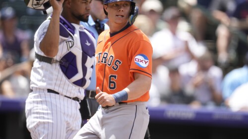 Houston Astros' Jake Meyers, front, scores on a single hit by Mauricio Dubon as Colorado Rockies catcher Elias Diaz (35) looks on in the third inning of a baseball game Wednesday, July 19, 2023, in Denver. (AP Photo/David Zalubowski)