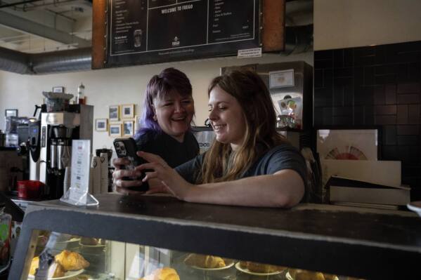 Renee Colon, co-owner of Fuego Coffee Roasters, talks to Claire Terrelli, an employee, Saturday, March 22, 2025, in Rochester, N.Y. (Max Conway via AP)