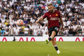 FILE - Manchester United's Luke Shaw shoots the ball during the Premier League soccer match between Tottenham Hotspur and Manchester United at the Tottenham Hotspur Stadium in London, England, on Aug. 19, 2023. Manchester United defender Luke Shaw is back in training after a three-month injury absence that has limited the England international to just two games this season. United says Shaw is back working with the main squad ahead of the Premier League game at Everton on Sunday. The left back sustained what United said was a “muscle issue” in August after appearing in the team’s opening two league games. (AP Photo/Alberto Pezzali)