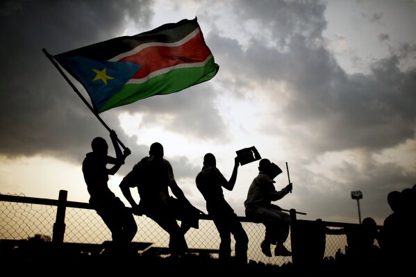 In this Sunday, July 10, 2011 file photo, Southern Sudanese wave the national flag in the capital Juba. (AP Photo/Pete Muller, File)
