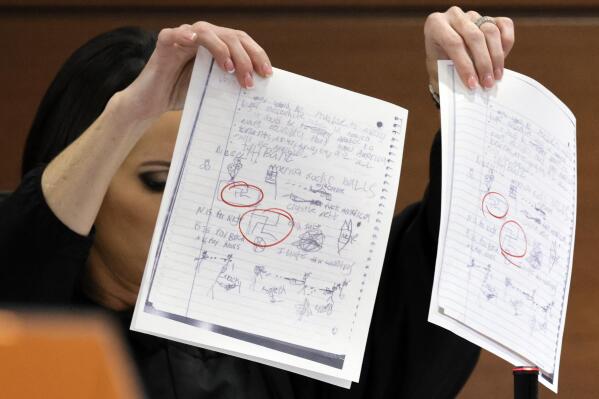 EDS NOTE: OBSCENITY - Judge Elizabeth Scherer holds up documents as she considers arguments from the defense that the jury should be prevented from seeing the swastikas on the pages (circled in red) during the penalty phase of the trial of Marjory Stoneman Douglas High School shooter Nikolas Cruz at the Broward County Courthouse in Fort Lauderdale, Fla., on Thursday, Sept. 1, 2022. Cruz previously pleaded guilty to all 17 counts of premeditated murder and 17 counts of attempted murder in the 2018 shootings. (Amy Beth Bennett/South Florida Sun-Sentinel via AP, Pool)